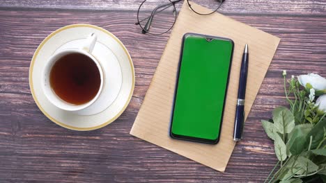 Top-view-of-smart-phone-and-notepad-on-table