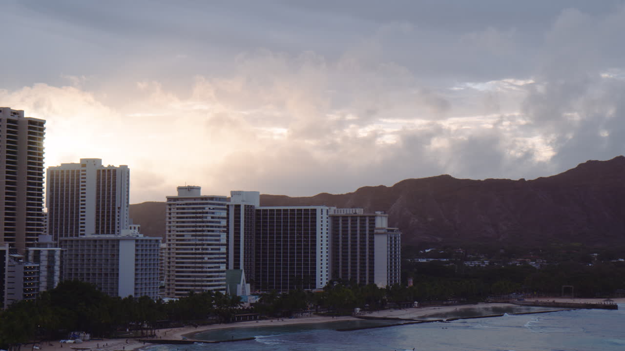 L'alba che sorge su hotel e resort di Waikiki, panoramica a destra, rivelando Diamond Head, Hawaii.