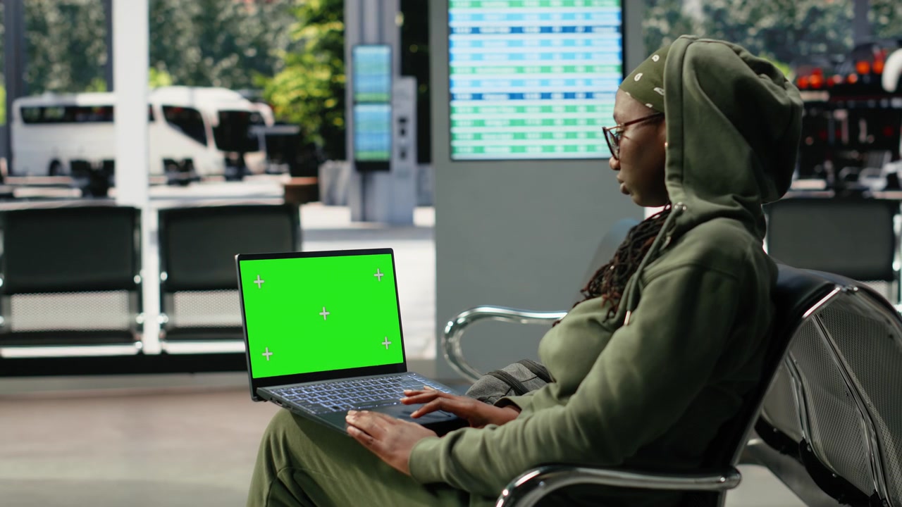 Notebook mockup con schermo verde usato da un viaggiatore nel terminal degli autobus