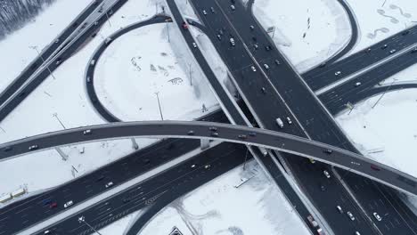 Vista-Aérea-De-Una-Intersección-De-Autopistas-Cubierta-De-Nieve-En-Invierno.