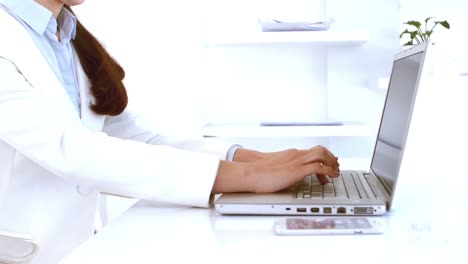 mujer de negocios escribiendo en su computadora portátil