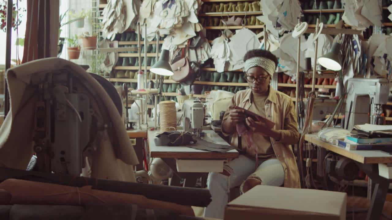 mujer afroamericana que trabaja en un escritorio en un taller de zapateros