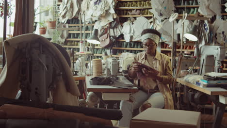 african american woman working at desk in shoemaker workshop