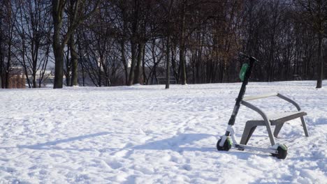 Scooter-Eléctrico-Abandonado-En-El-Parque-Durante-El-Tiro-Estático-De-Invierno-Nevado-1