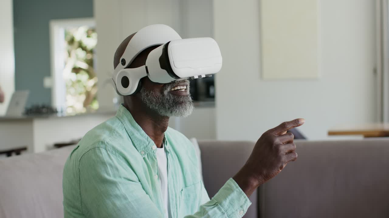 Ældre par, afroamerikansk mand med VR-headset laver bevægelser til VR-spil, kvinde bruger telefon