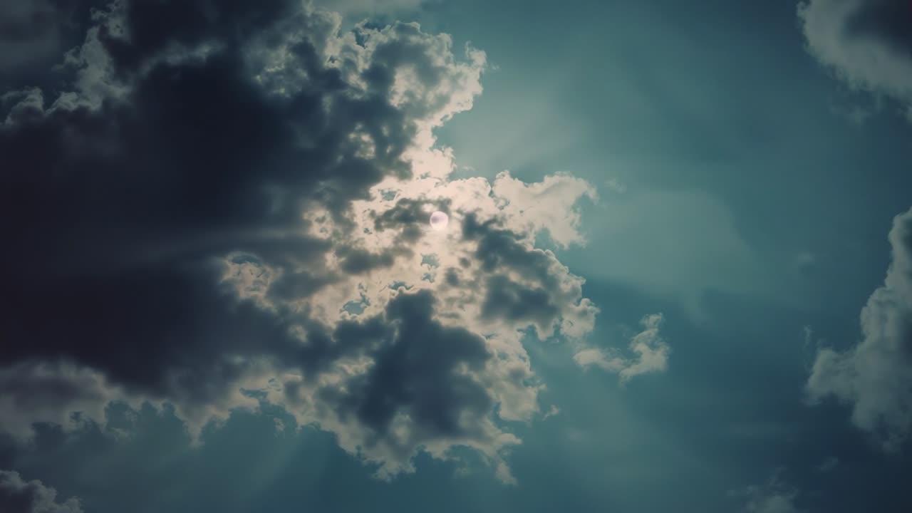 Drifting wind-driven cloud formation revealing sunlight rays in daytime sky, with radiant glow