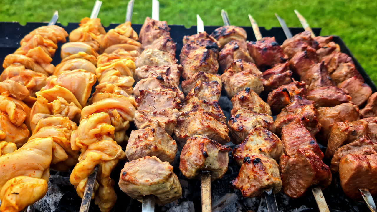 Grilled skewers with meat over open flame, sizzling and golden brown