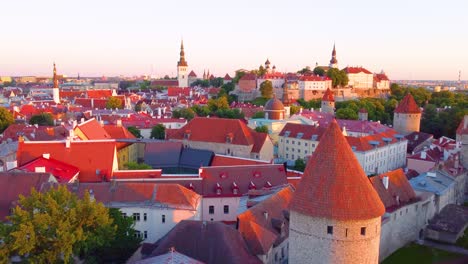 aerial drone view of stunning architectural buildings with red roof, glowing in dusk sunlight in tallinn, estonia.