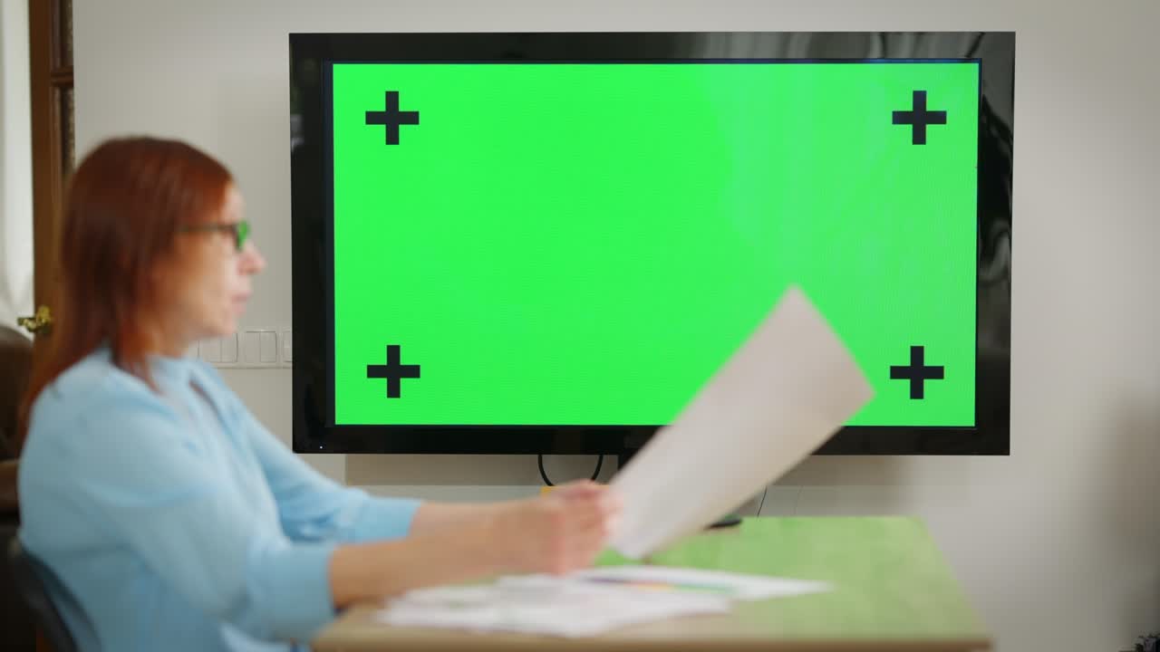 녹색 화면 벽에 흐릿한 성숙한 관리자가 온라인에서 프로젝트 전략을 설명하고 있습니다. 자신감있는 여성 백인 분석가 모형 웹 컨퍼런스에서 동료를 설득합니다.