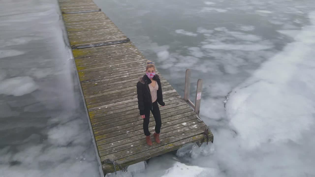 갓난 아기가 옆에 누워 있는 동안 침대에 앉아 노트북 컴퓨터에서 일하는 젊은 어머니