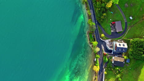 Vista-Aérea-Desde-El-Seguimiento-De-Drones-A-Lo-Largo-De-Una-Carretera-Junto-A-Un-Lago-En-Austria