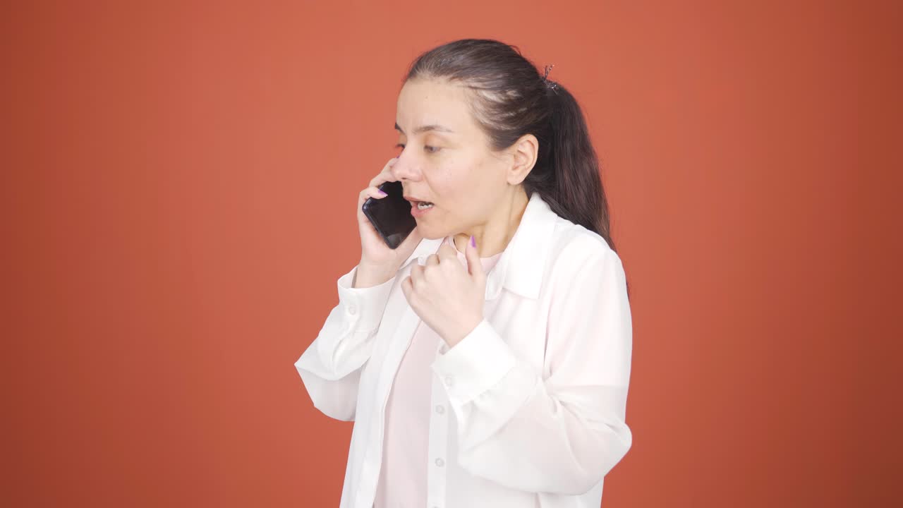전화로 이야기하는 여성의 전화가 충전되지 않습니다.