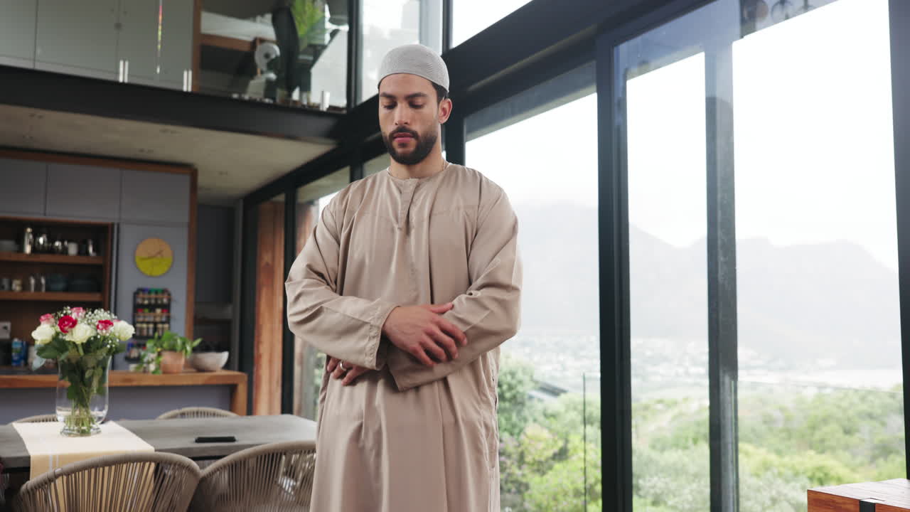 Ung muslimsk mand udfører bøn i moderne hjem.