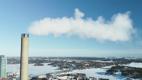 aerial shot of a flue-gas stack in winter, slowly pulling out