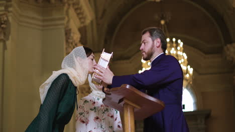 priest kissing the bible