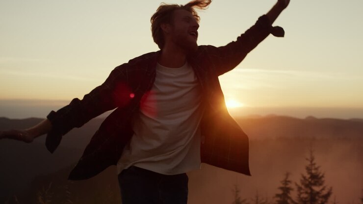 Man dancing in mountains at sunset