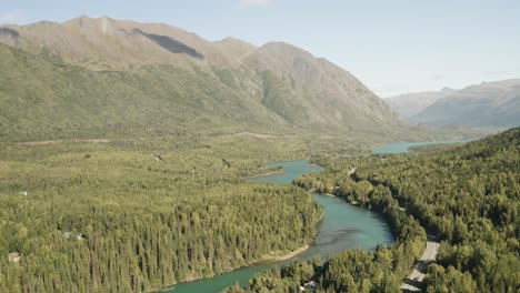 Aerial-landscape-view-of-water-river-with-green-mountains-in-Alaska-Usa,-national-park-unpolluted-natural-mountains-wilderness-with-tree-forest-woodland