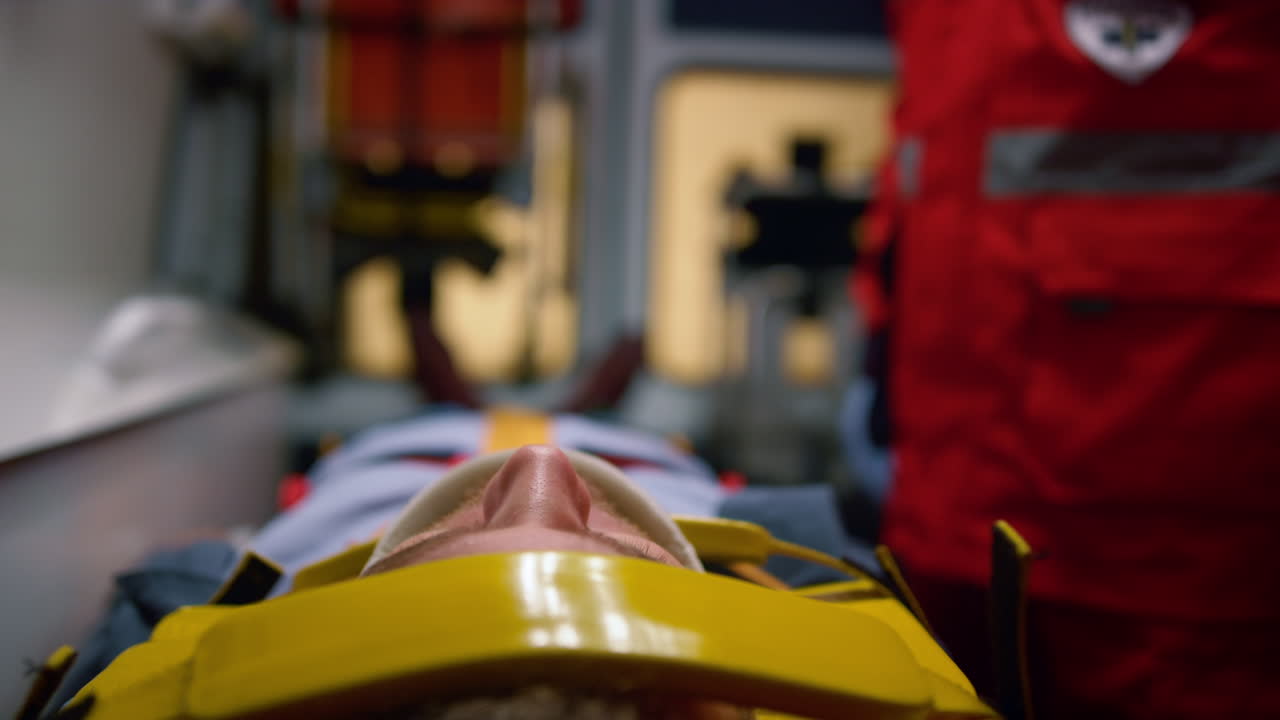 hombre acostado en camillas en el coche de ambulancia. paciente masculino con collar de cuello