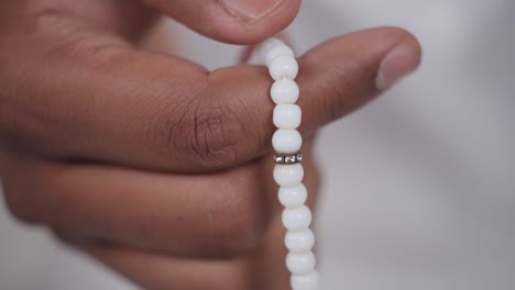 closeup of indian muslim man doing praying beads