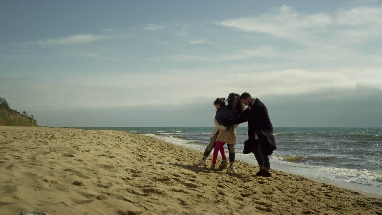 una encantadora familia abrazándose en la playa. mamá, papá, hijo disfrutando de las vacaciones juntos.