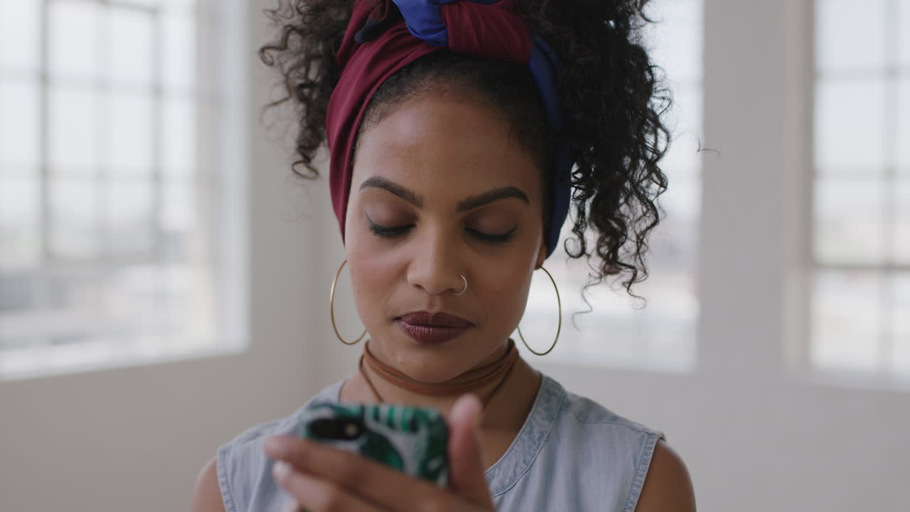 ritratto in slow motion di una giovane donna ispanica in un nuovo appartamento che invia messaggi di testo navigando utilizzando la tecnologia dei social media dello smartphone