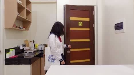 portrait of teenage student entering the door of an apartment