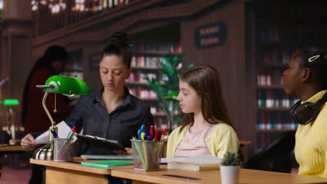 profesor ayudando a los estudiantes en un entorno de biblioteca