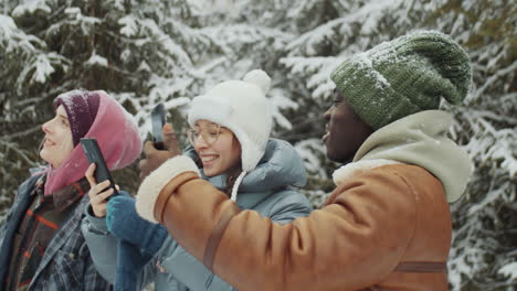 friends taking pictures of winter forest