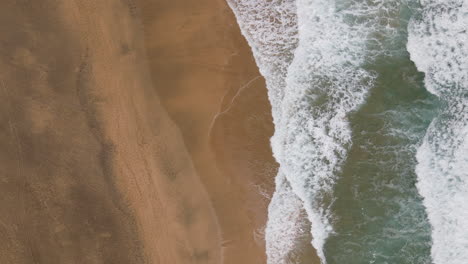 fantastic aerial aerial shot of the shore of cofete beach and with the waves breaking on the shore