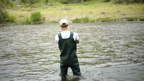 slow motion shot of a caucasian male fisherman casting his hook while fly fishing-12