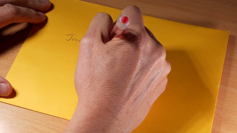 man addresses a yellow envelope