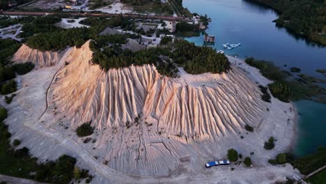 drone video highlights rummu quarry in estonia with clear blue water over submerged ruins ash hills and green forest offering one of the most cinematic natural scenes
