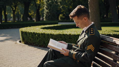 military officer reading a book in a park