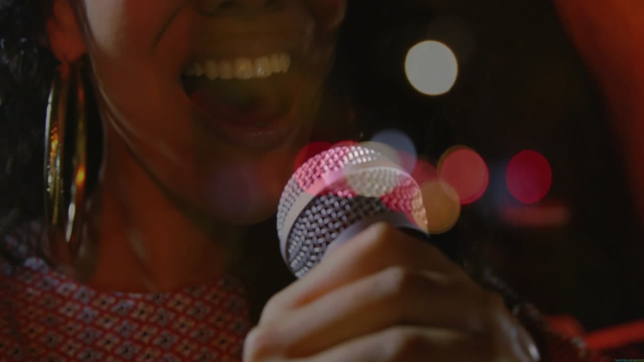 Singer leaning into mic, moving from verse to strong chorus with lights moving for music expression