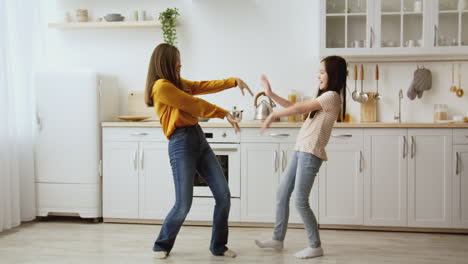 mother and daughter dancing in the kitchen