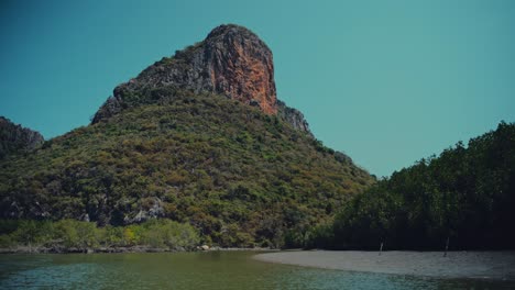 uma grande colina de calcário sobe em frente ao leito do rio