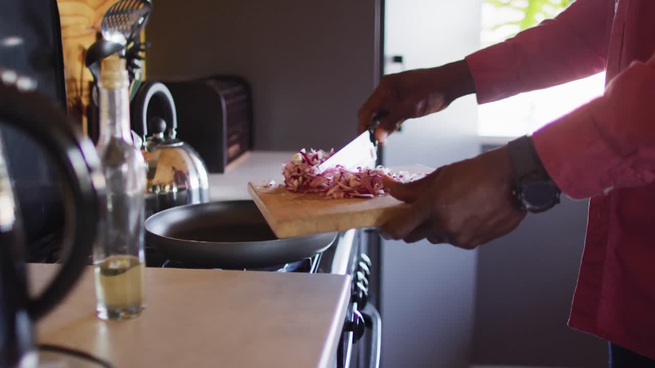 Mid section of senior african american man spending time in log cabin, cooking in kitchen