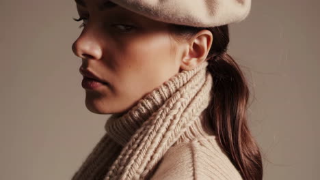 close-up of a woman wearing a beige knit turtleneck sweater