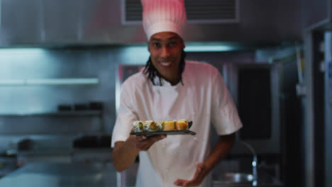 cocinero de raza mixta de pie en la cocina haciendo un buen plato de sushi