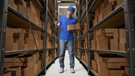 full body of asian male courier in blue uniform showing puzzled gesture and saying what while delivering a carton in warehouse