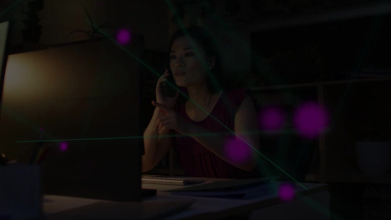 Video vertical: Mujer atendiendo una llamada telefónica y manejando una laptop para trabajar mientras nodos enlazan datos empresariales