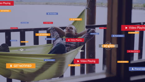 relaxing in hammock, man viewing animation of social media notifications outdoors