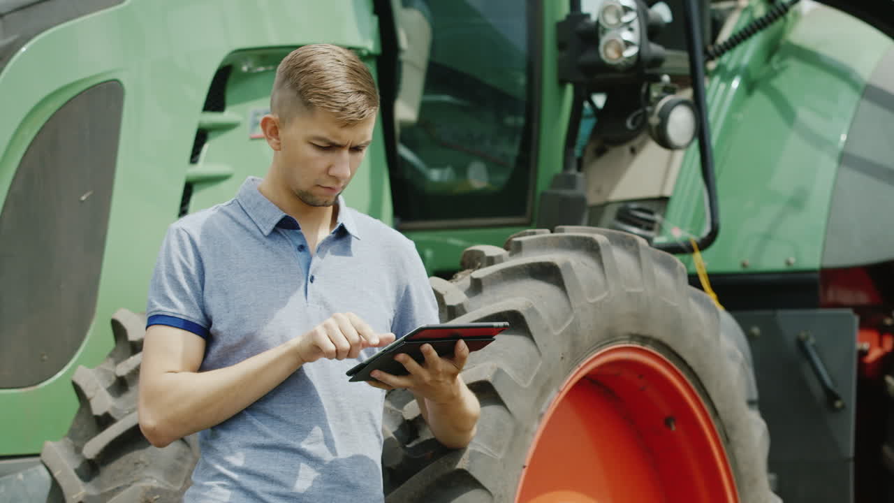 젊은 백인 농부가 태블릿 4로 현장에서 일하고 있습니다.