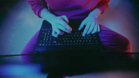 hombre trabajando rápidamente en la computadora portátil en la casa iluminada durante la navidad