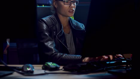 Attractive-Female-Software-Developer-In-Glasses-Working-Over-The-Hacking-Programs-At-The-Dark-Room,-Then-Leaning-On-The-Chair-And-Resting-From-Tensive-Job