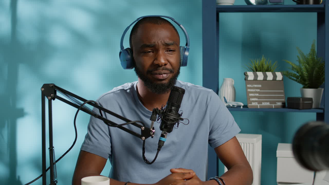 Cheerful vlogger waving at camera while recording podcast