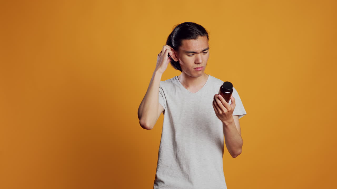 Modern guy being uncertain about bottles of drugs