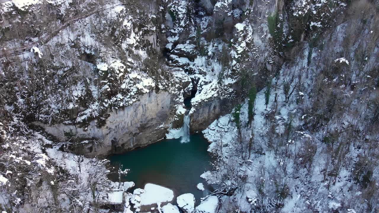 scatto remoto della cascata nell'aria nevosa, drone che vola sopra la testa in un paesaggio straordinario