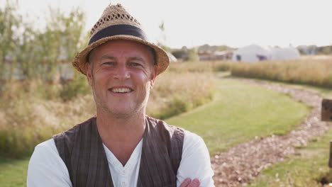 portrait of smiling mature man visiting yurt campsite in countryside