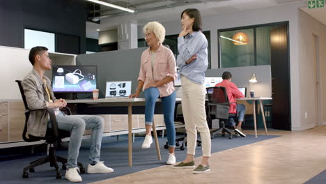 discussing project, diverse team collaborating with computer screens in modern office